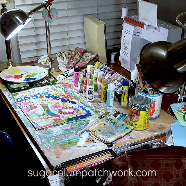 desk with colorful paints and art supplies