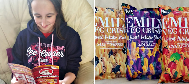 My teenage daughter reading a takeaway menu and a selection of vegetable crisps