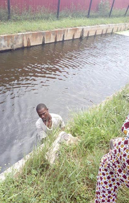 Photos: Bus Conductor jumps into Canal in Lagos after plan to transfer passengers into another bus backfires
