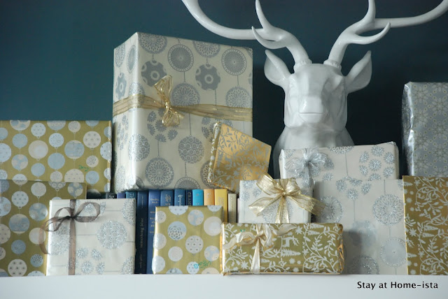 silver and gold gifts on a mantle with a deer head