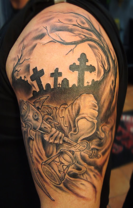 Death tattoo covering the shoulder and the arm: Death in a graveyard title=