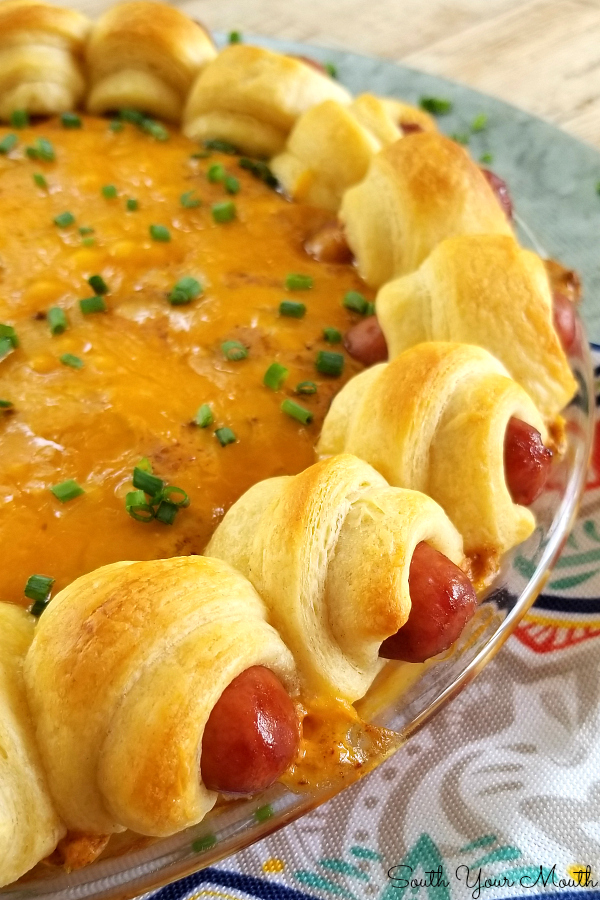 Pigs in a Blanket Chili Cheese Dippers! A perfect party, tailgating or game day appetizer recipe made from an easy chili-cheese dip baked under a wreath of Pigs In a Blanket.