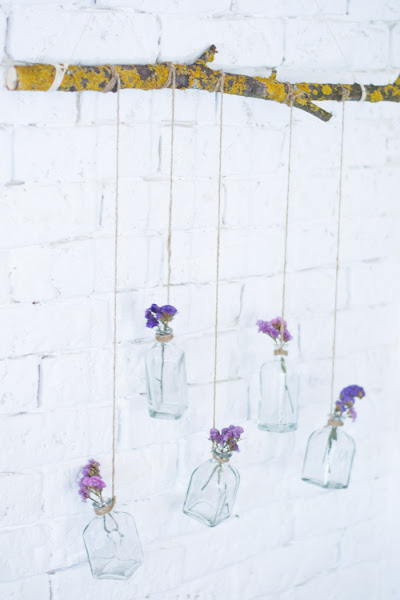 Rama con botellas de cristal y flores