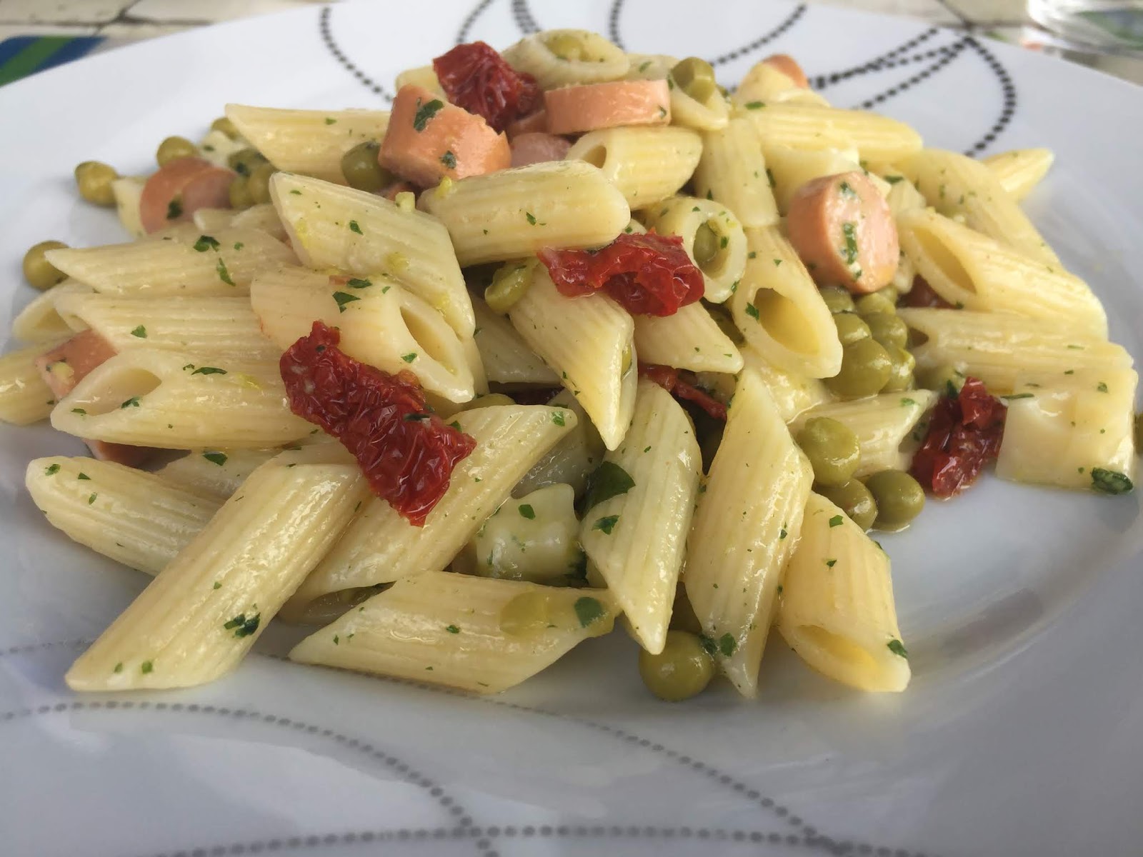 Pasta fredda mezze penne con piselli, wurstel, formaggio e pomodorini