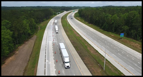 Volvo Trucks North America, in collaboration with FedEx and the North Carolina Turnpike Authority, successfully demonstrated on-highway truck platooning on N.C. 540 today as part of ongoing research collaboration. The “platoon” consisted of three Volvo VNL tractors, each pulling double 28 ft. trailers, connected through wireless vehicle-to-vehicle communication technology to help reduce the reaction time for braking and enabling the vehicles to follow closer, automatically matching each other’s speed and braking.