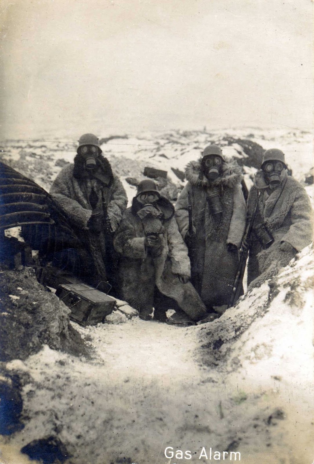 Four German soldiers wearing fur coats and gas masks in a trench, 1917.