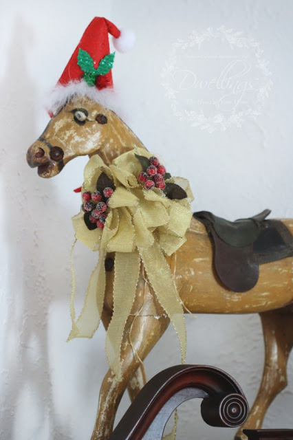 Primitive pull toy horse decorated for Christmas with hat and berry ribbon.