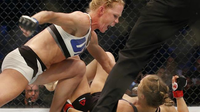 Holly Holm goes in for the finishing blow after dropping Ronda Rousey with a head kick at UFC 193.