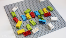 A LEGO base plate showing LEGO Braille Bricks in 5 colours