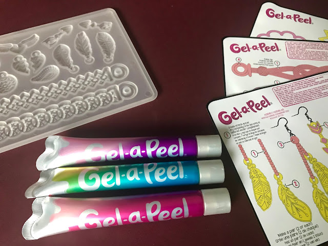 A close up of the gel-a-peel tubes in pink, purple and greeny blue, the tray mould and templates   