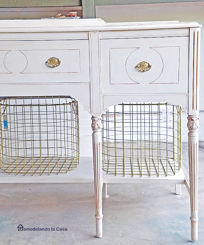 dark buffet painted white with gold hardware and metal bin baskets