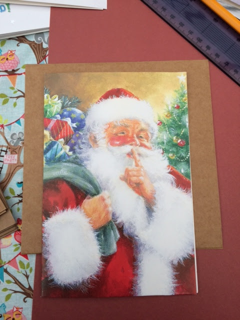 A Santa Christmas card being cut to size