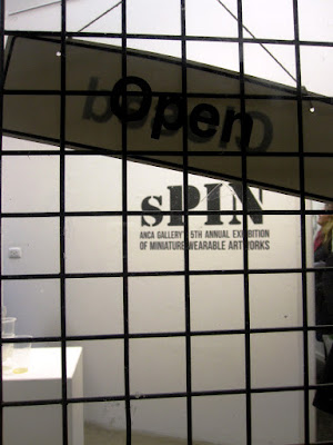 Open sign on the door to the sPIN exhibition at ANCA gallery.
