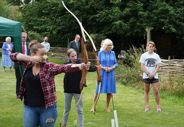 Duchess of Cornwall, Patron of Community First, visited Oxenwood Outdoor Education Centre. She wore a blue summer dress and pearl earrings