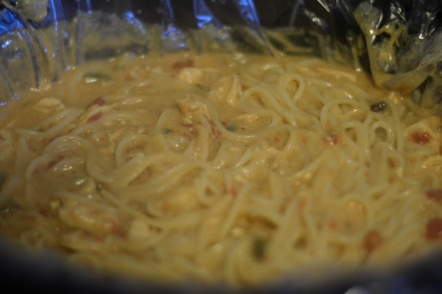 The fully cooked chicken spaghetti in the crockpot. 