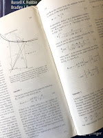 Appendix 1 in the paper The Electric Field Induced During Magnetic Stimulation by Roth, Cohen ad Hallett (Electroencephalography and Clinical Neurophysiology, Suppl 43: 268-278, 1991), superimposed on the cover of Intermediate Physics for Medicine and Biology.