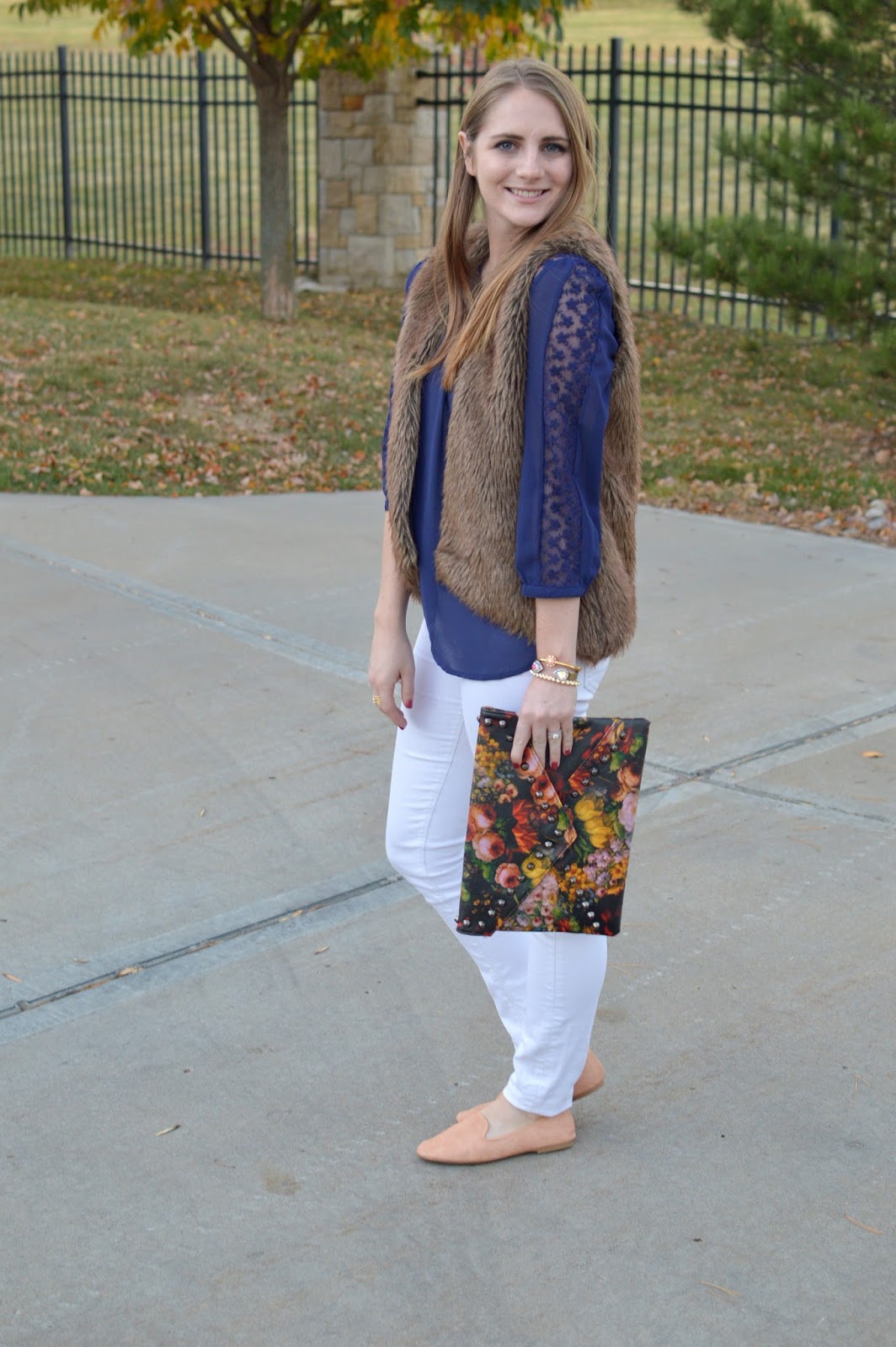 navy lace top with white jeans and a faux fur vest