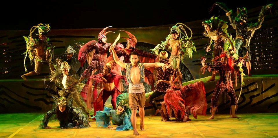 Tanghalang Pilipino's stage production of the Ibalong. Handyong stand at the front with bolo raised high above his head.  All sorts of costumed beasts lurk behind him.