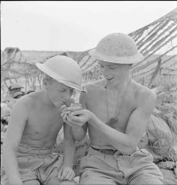 Lighting up a mate at Tobruk, 10 November 1941 worldwartwo.filminspector.com