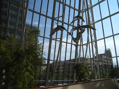 Stainless steel geese overhead inside a curtain wall atrium