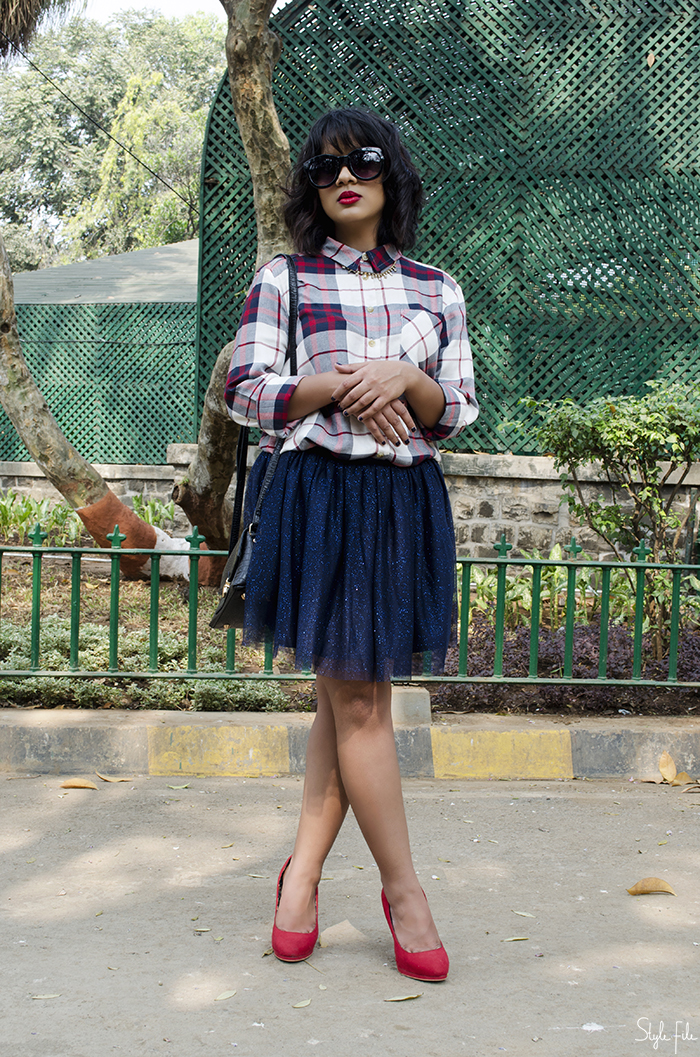 Image of Indian fashion blogger wearing a plaid checked shirt, tutu skirt, red high heels with a mini bag, collar necklace and highlighted skin