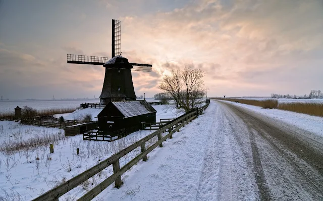 Molen langs een weg in de winter met sneeuw