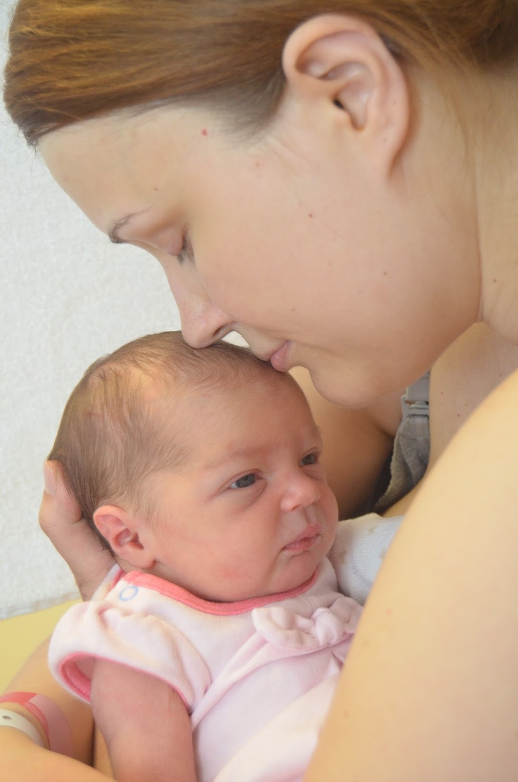 new mum giving a kiss to a newborn girl