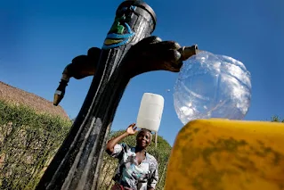 Woman collects water in Costa del Sol near Maputo, Mozambique