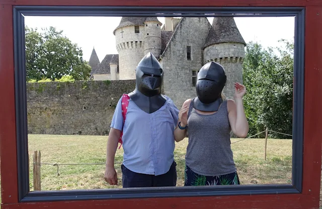 Me and G wearing knights helmets in front of a french chateau
