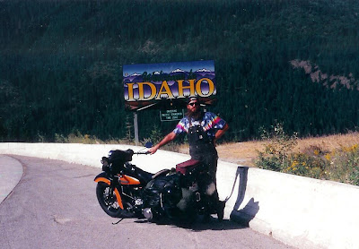 1947 Harley Knucklehead motorcycle and rider in tie-dye at Idaho border sign