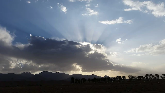 Sol atrás das nuvens com seus raios iluminando