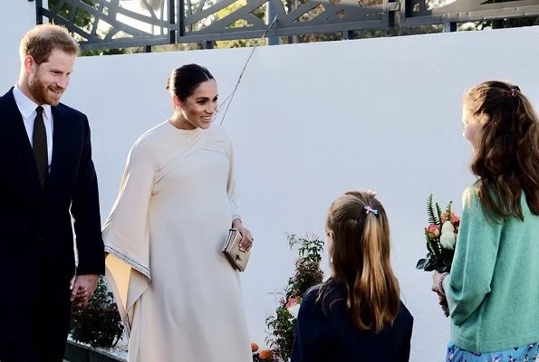 Meghan Markle wore a bespoke dress by Dior featuring draped sleeves and Birks Snowflake Snowstorm diamond earrings