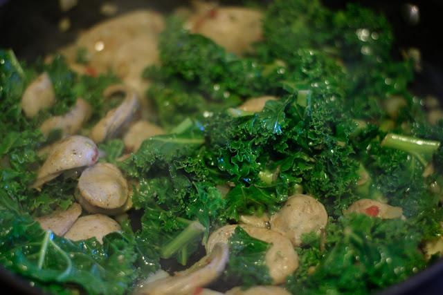 The fully cooked chicken sausage and kale in the pan. 