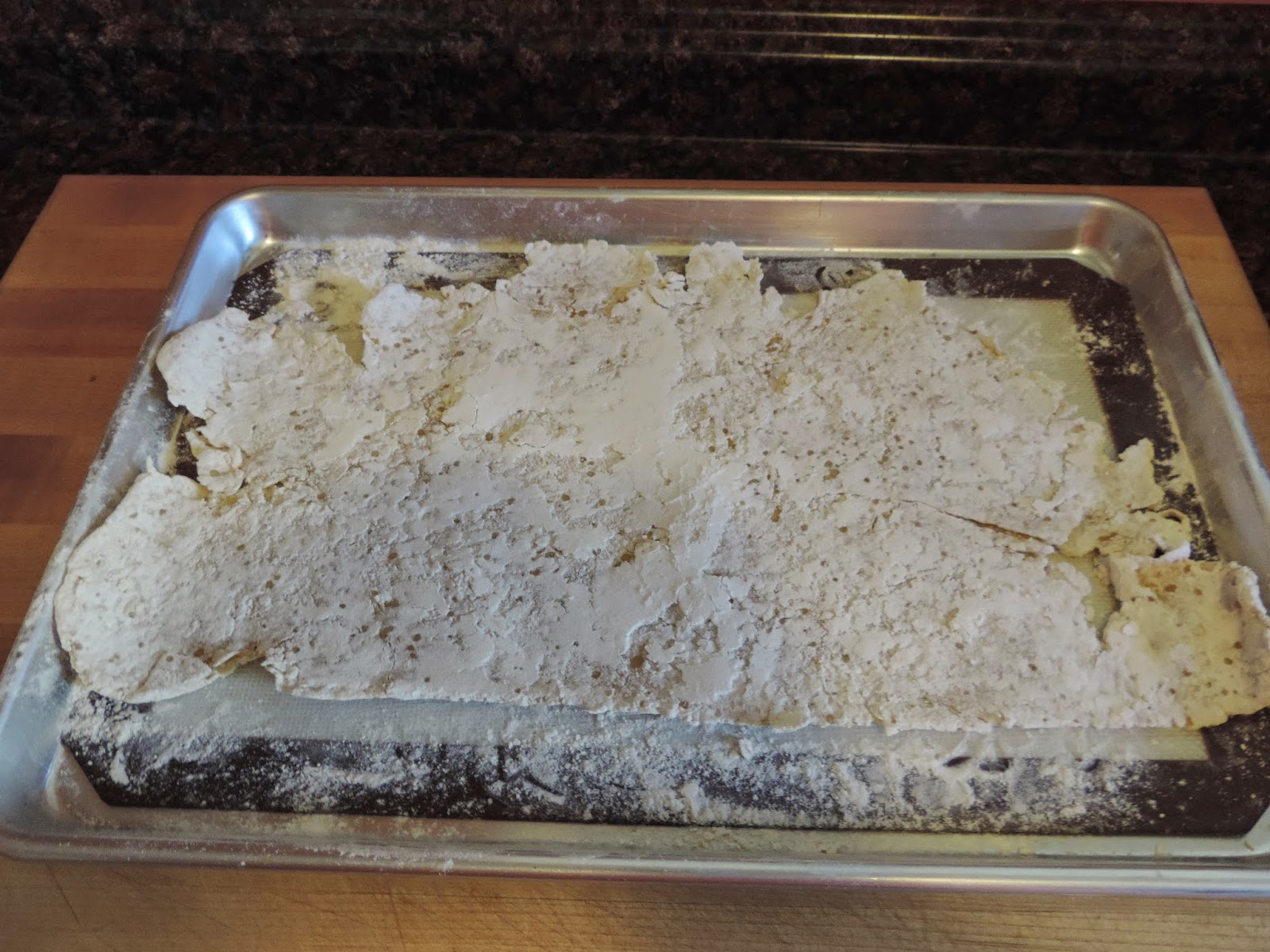 The rolled out dough on a floured baking sheet, drying. 