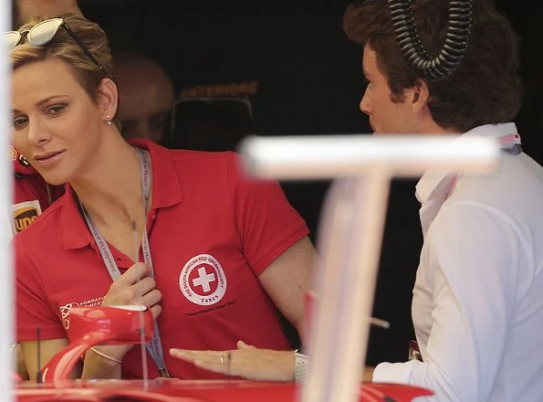 Prince Albert and Princess Charlene at Formula 1 Grand Prix. Princess Charlene wearing the T Shirt of the red cross of Monaco