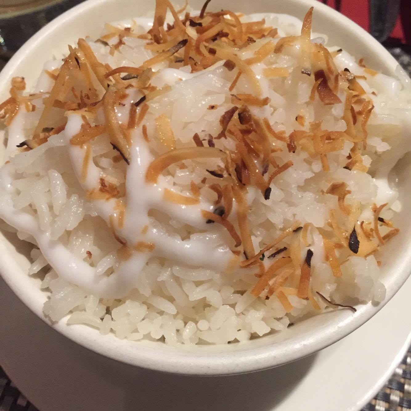 Side dish of coconut rice drizzled with coconut cream