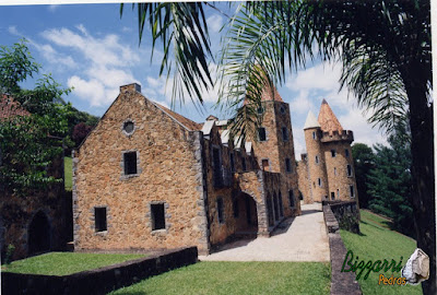 Castelo de pedra, com a torre de pedra, construído com pedra moledo nessa cor mesclada.