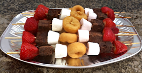 Lots of the sweet treat kebabs on a metal tray.