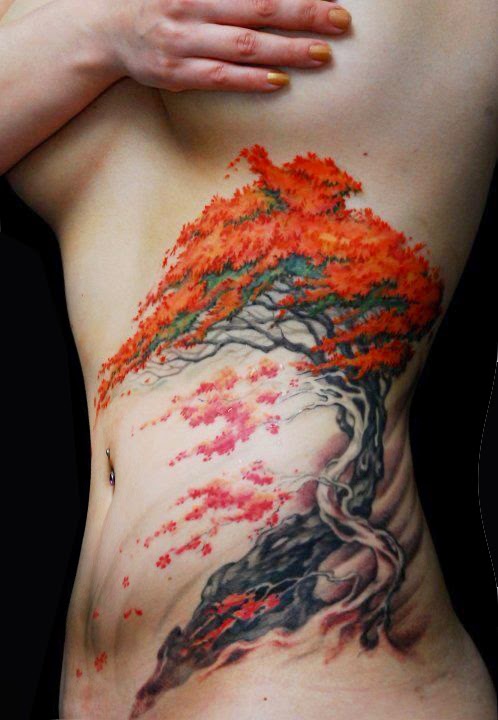 vemos a una chica de pefil que lleva en el costado el tatuaje de un arbol de tonos anaranjados