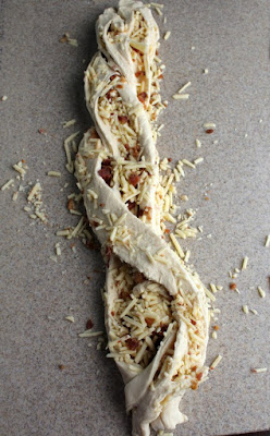 cheddar and bacon bread dough folded over itself in a loose braid