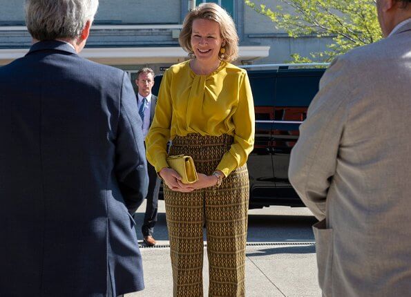Queen Mathilde wore Natan yellow silk blouse and print pants. Natan clutch bag. Dries Van Noten print trousers