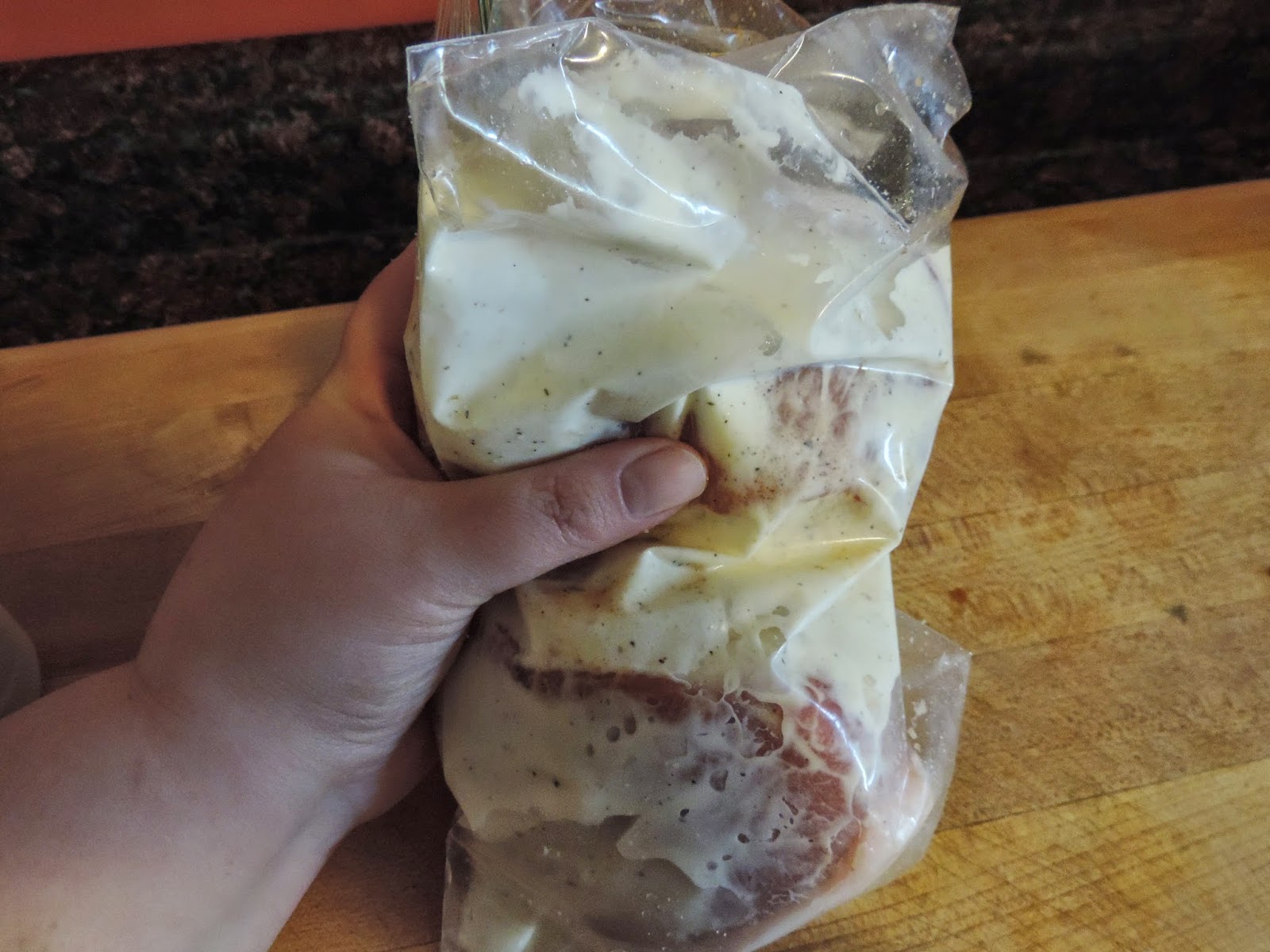 The ranch being rubbed into the pork chops, inside the bag.  