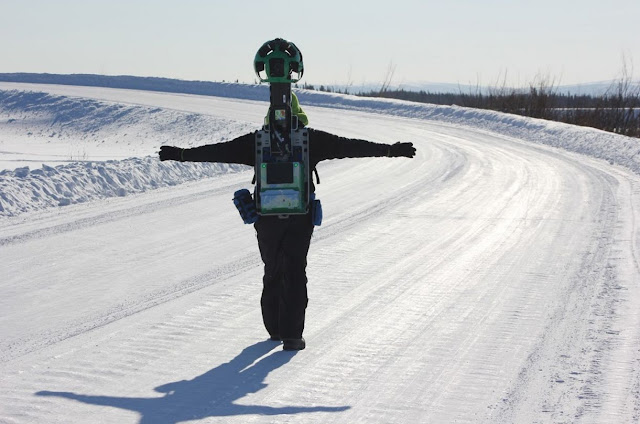 Ein Mann mit einem Street View Trekker auf dem Rücken läuft durch den Schnee