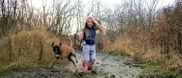 girl and dog running through muddy water wet puddle splash