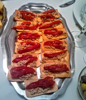 Tostadas finas de atún en aceite y pimientos rojos asados.