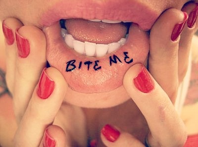 Tatuaje en los labios con la palabra muerdeme