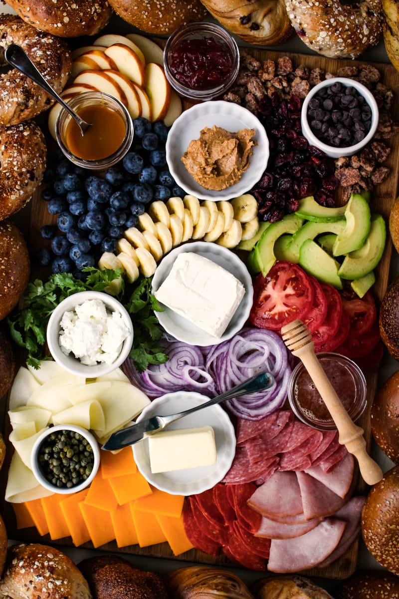 The Ultimate Bagel Bagel Brunch Board featuring New Yorker Bagels is loaded with bagel toppings galore!  A variety of spreads, fruits, vegetables, cheeses, meats, and a few unique toppings make this bagel board a showstopper. #breakfast #brunch #bagels #ad 