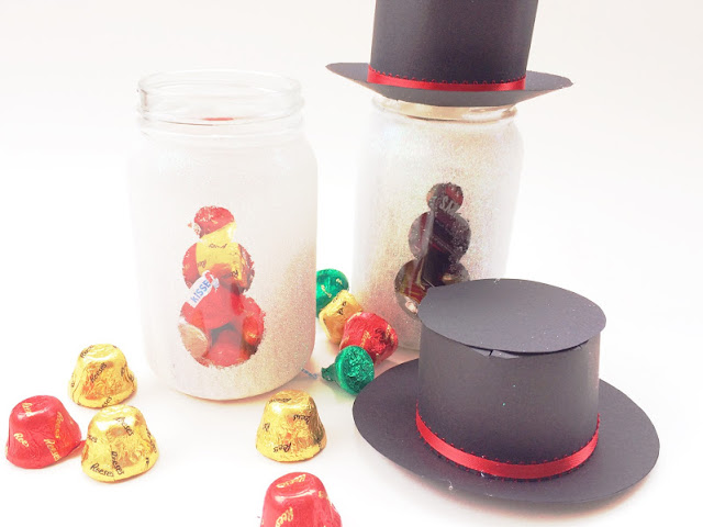 Make a snowman that will last all year long and is super cute with a bit of sparkle, a cute magic hat, and some yummy chocolate candies.  This snowman gift jar is the perfect Teacher gift, neighbor gift, or gift for your best friend.  It's easy and worth every little bit of glitter.