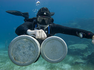 sidemount diver with 2 cylinders extended in front practicing skills underwater