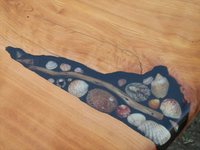 Mesa de madera con resina cristal y conchas de mar encapsuladas.  